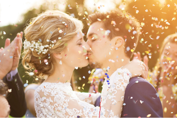 a couple kiss while confetti flies through the air