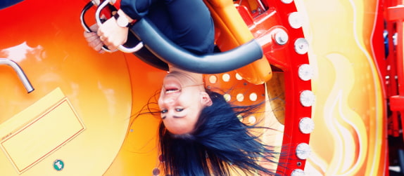 a woman screams as a roller coaster flips her upside-down