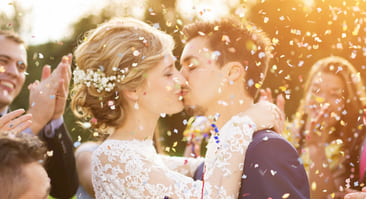 a couple kiss while confetti flies through the air