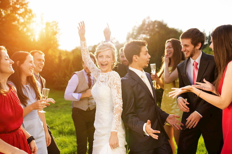 wedding guests dance while the sun sets