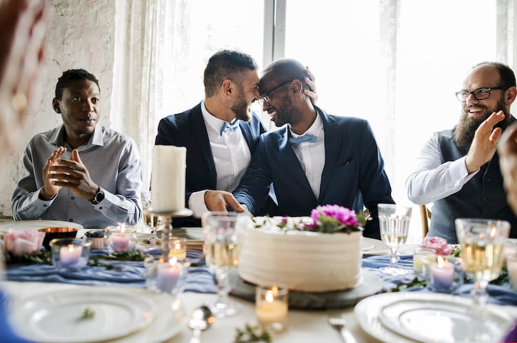 a couple sit at their head table with wedding guests